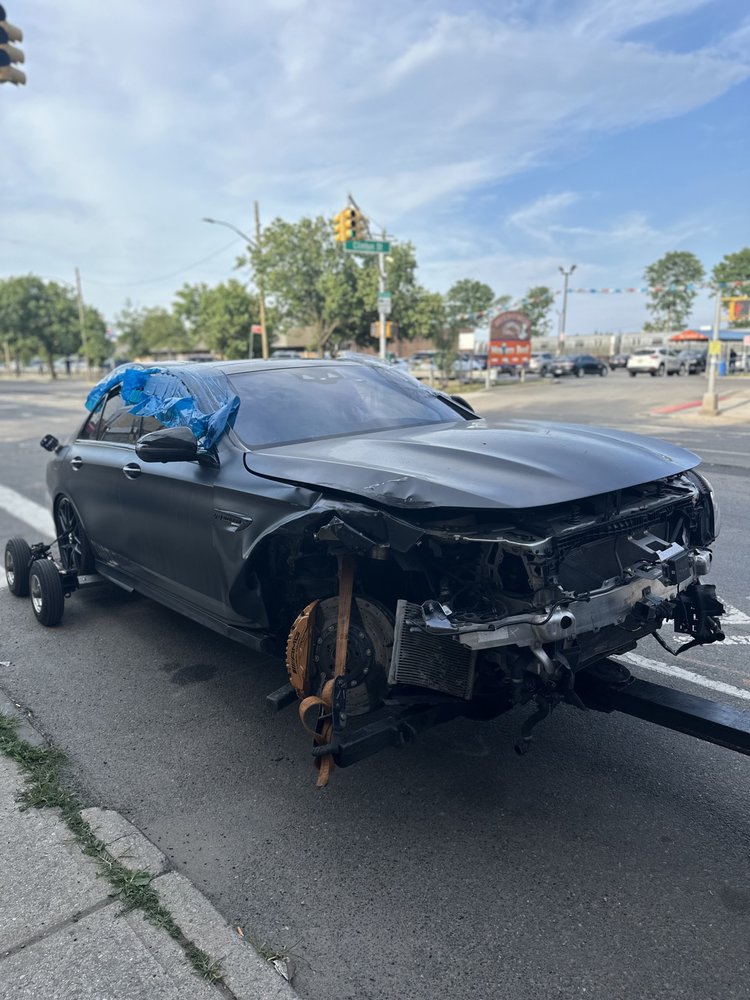 Accident-damaged sedan at the roadside awaiting recovery