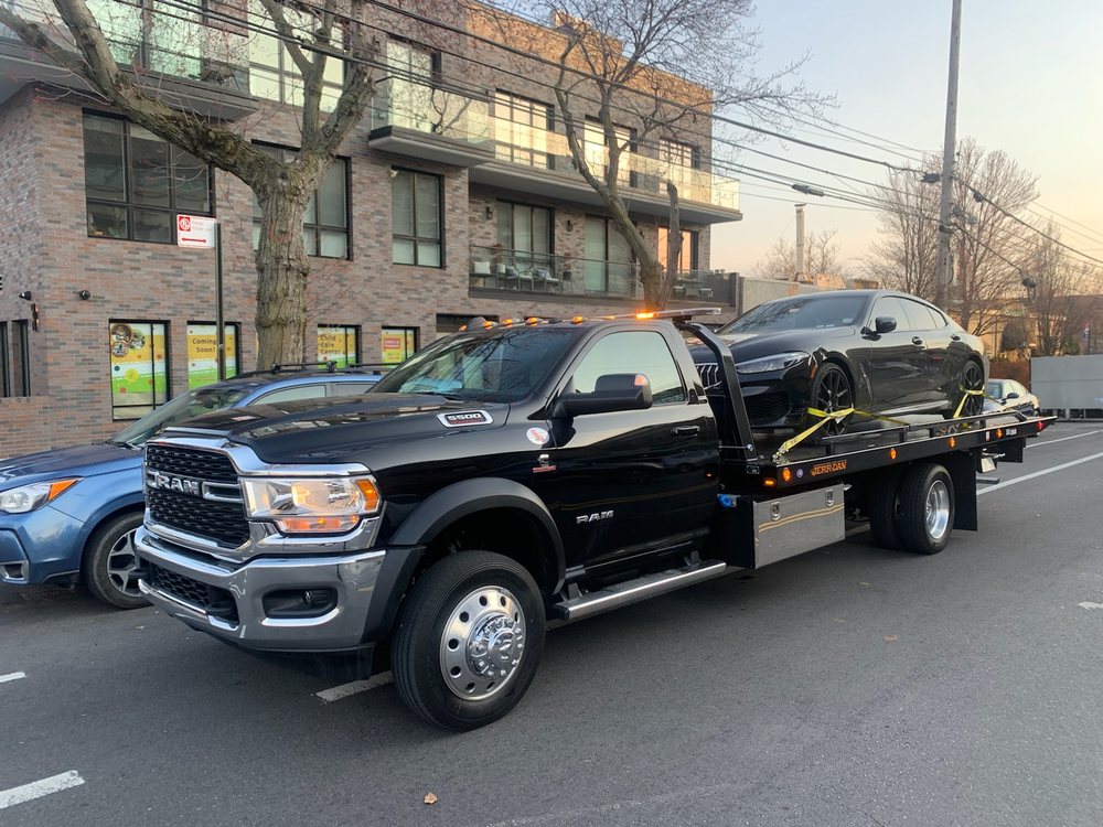 Flatbed tow truck with its deck lowered and ready to load