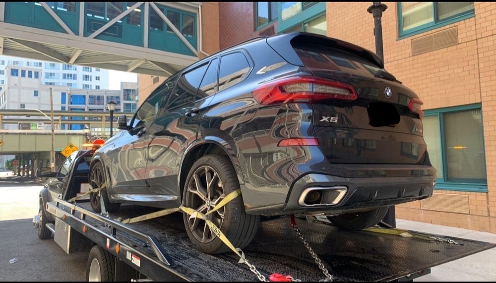 SUV being winched onto the deck of a flatbed tow truck