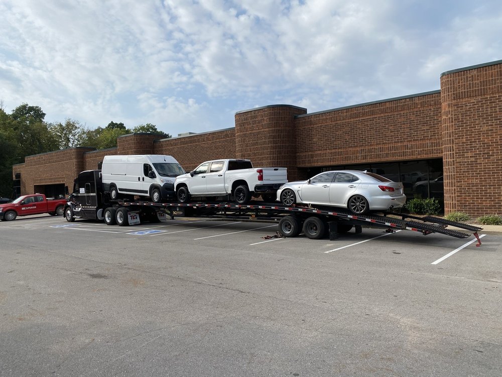 Multi-vehicle carrier loaded with pickup trucks for long distance transport