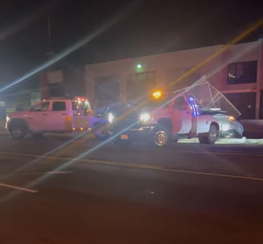 Tow truck working a roadside scene at night with warning lights
